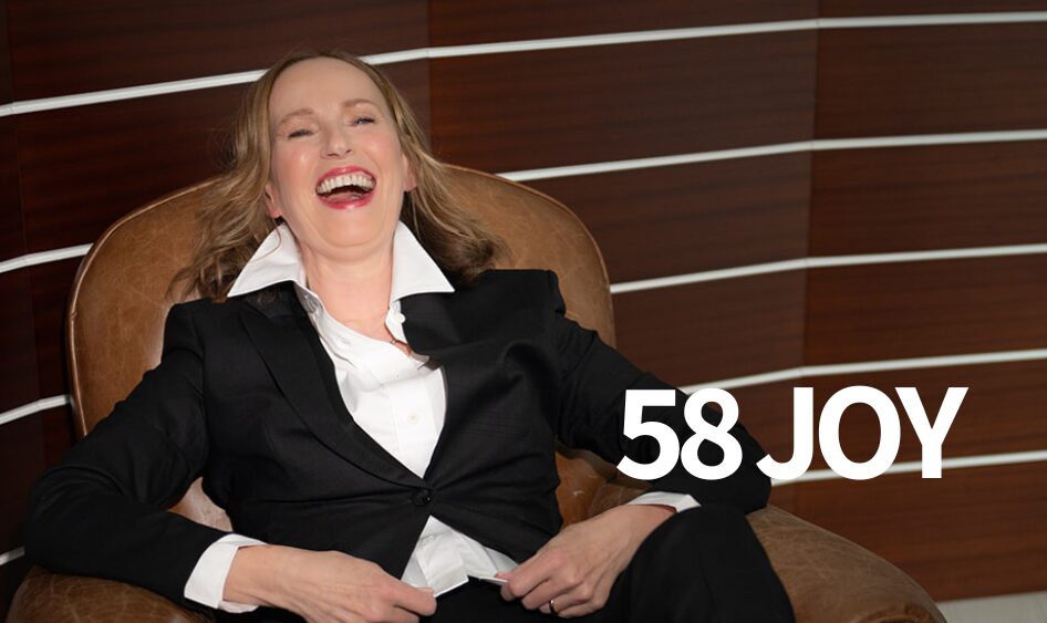 Iris Seng lacht entspannt im Sessel - Symbol für Lebensfreude, Vitalität und Human Design Gate 58 Joy